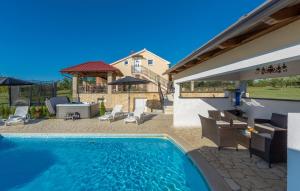 a swimming pool with a patio and a house at Villa Ivda in Porec Area in Nova Vas