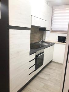 - une cuisine avec des placards blancs et un évier dans l'établissement Delizioso Appartamento in Via di Monte Verde, à Rome