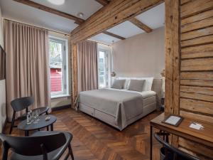 Schlafzimmer mit einem Bett, einem Tisch und Stühlen in der Unterkunft Boutique Hotel Rosenplänter in Pärnu