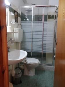 a bathroom with a toilet and a sink and a shower at Mantraki Hotel Apartments in Agios Nikolaos