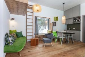 ein Wohnzimmer mit einer grünen Couch und einem Tisch in der Unterkunft Loisach 2 in Grainau