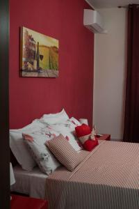 a bedroom with a bed with a red wall at LA CASA DI MAMMA 'NTO in Castrofilippo