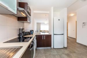 eine Küche mit einem weißen Kühlschrank im Zimmer in der Unterkunft Algarve Race Resort - Apartments in Portimão