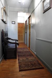 an empty hallway with a chair and a rug at Heatopia Apartment in Newcastle upon Tyne