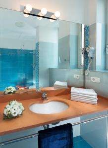 een badkamer met een wastafel en een spiegel bij Hotel Parigi in Bibione