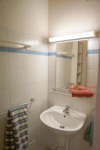 a white bathroom with a sink and a mirror at VVF Luberon Provence in Murs