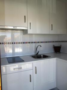 a kitchen with white cabinets and a sink at Apartamento Terranova La Placeta in Alhama de Granada