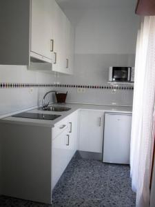 a white kitchen with a sink and a refrigerator at Apartamento Terranova La Placeta in Alhama de Granada
