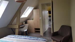 1 dormitorio con cama, escritorio y ventana en nid cauchois en Betteville