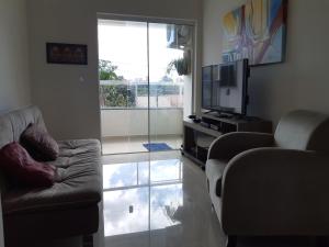 sala de estar con sofá y TV en Apto 2 dorm a 750m da praia, en Florianópolis