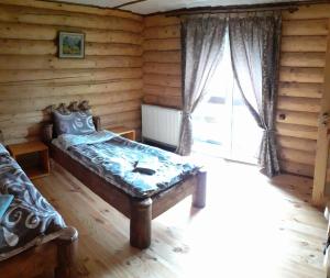 Pokój z łóżkiem i dużym oknem w obiekcie Sadyba Cherry w mieście Pilipets