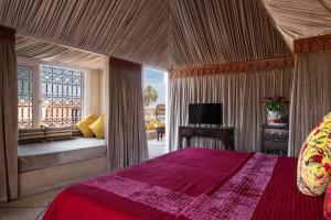 a bedroom with a red bed and a tv in it at Riad Spice by Marrakech Riad in Marrakesh