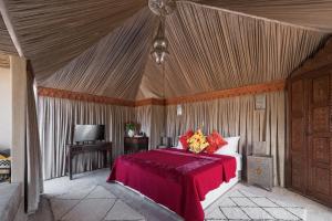 ein Schlafzimmer mit einem Bett und einem TV in einem Zelt in der Unterkunft Riad Spice by Marrakech Riad in Marrakesch