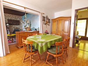 una sala da pranzo con tavolo e sedie verdi di Apartments and room Rabac 155 a Rabac