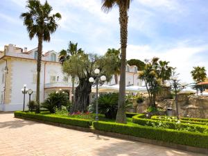 a resort with palm trees and a building at Resort Villa Antica in Eboli