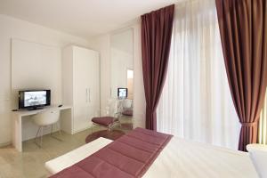 pokój hotelowy z łóżkiem i telewizorem w obiekcie Ferrara Rooms w mieście Ferrara