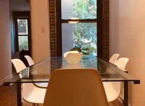 紐約的住宿－Two Bedroom Harlem Apartment，一间设有玻璃桌和白色椅子的用餐室