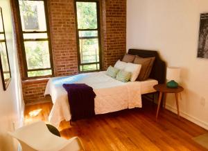 1 dormitorio con cama y pared de ladrillo en Two Bedroom Harlem Apartment en Nueva York