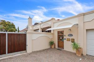 a white house with a gate and a fence at Arum Guest House in East London