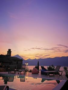 a resort with a pool with a sunset in the background at Locanda San Marco in Torri del Benaco