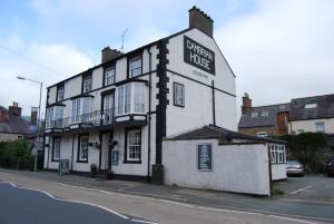 a white building with a sign on the side of it at Cambrian House in Llangollen