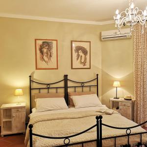 a bedroom with a bed and two pictures on the wall at Villa Toscana in Hajdúszoboszló