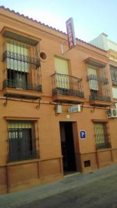 un edificio con balcones en un lateral en PENSIÓN LARRA, en Mairena del Alcor