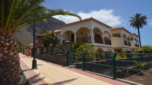 een huis met een palmboom en een hek bij Apt. Heliconia Nº 5 in Valle Gran Rey