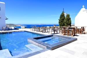a swimming pool with a table and chairs at Aletro Cottage Houses in Mýkonos City