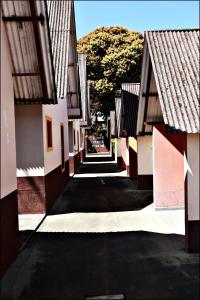 an empty alley between two buildings with trees at Pousada O Caipira in Pouso Alto