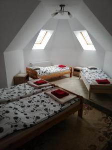 a attic room with three beds and two windows at Potok 5 in Złoczew