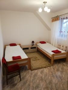 a bedroom with two beds and a chair in it at Potok 5 in Złoczew