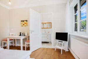 Habitación blanca con escritorio y TV. en Ferien Hohes Elbufer en Schnakenbek