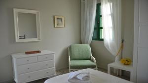 バジェ・グラン・レイにあるCasa Olivier La Playa bajoのベッドルーム(緑の椅子、ドレッサー付)