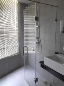 a bathroom with a shower and a tub and a sink at Nilaveli Ocean Front Luxury Apartments in Trincomalee