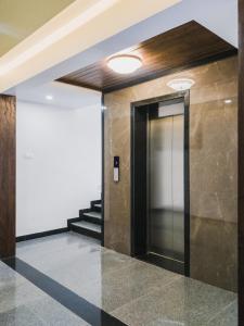 un pasillo con una puerta y escaleras en un edificio en D' Manor Service Apartment, en Belgaum
