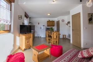 a living room with a couch and a table and a kitchen at Gîtes de la Bresse in Saint-Georges-des-Hurtières