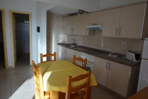 een keuken met een tafel en een gele tafel en stoelen bij Apartamentos El Sombrero in Acantilado de los Gigantes
