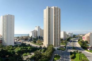 a city with tall white buildings and a road at Rocha Tower by Beach Rentals in Portimão