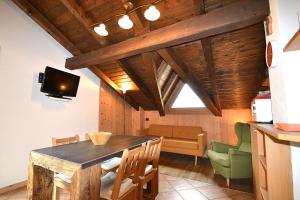 comedor con mesa, sillas y TV en Appartamenti Calanda - Livigno Center en Livigno