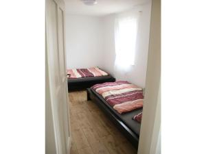 2 Betten in einem kleinen Zimmer mit Fenster in der Unterkunft Haus Mersche in Gösenroth