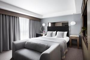 a bedroom with a large bed and a chair at Kimpton - Blythswood Square Hotel, an IHG Hotel in Glasgow