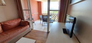 un soggiorno con un divano e un tavolo di Studio vue mer et Esterel ad Agay - Saint Raphael