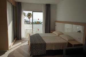 a bedroom with a bed and a view of the ocean at Apartamentos El Sombrero in Acantilado de los Gigantes