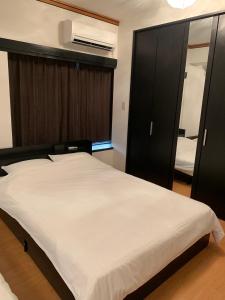 a bedroom with a large bed and a mirror at ガナダン中央駅 3f 無料駐車場 in Kagoshima