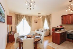 cocina y sala de estar con mesa y sofá en ApartHotel Belvedere Residence Becici Budva, en Budva