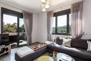 sala de estar con sofá y TV en Villa Kalli Crete, en Adelianos Kampos