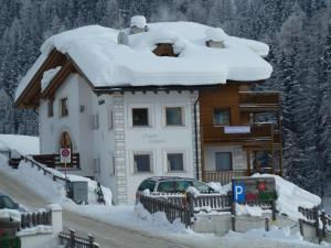 a house covered in snow with a car parked in front at Chasa Vaidum in Samnaun