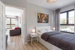 1 dormitorio blanco con 1 cama y 1 silla en Chill Apartments Wolska 45 en Varsovia