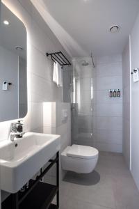 a white bathroom with a sink and a toilet at Reykjavik Residence Apartment Hotel in Reykjavík